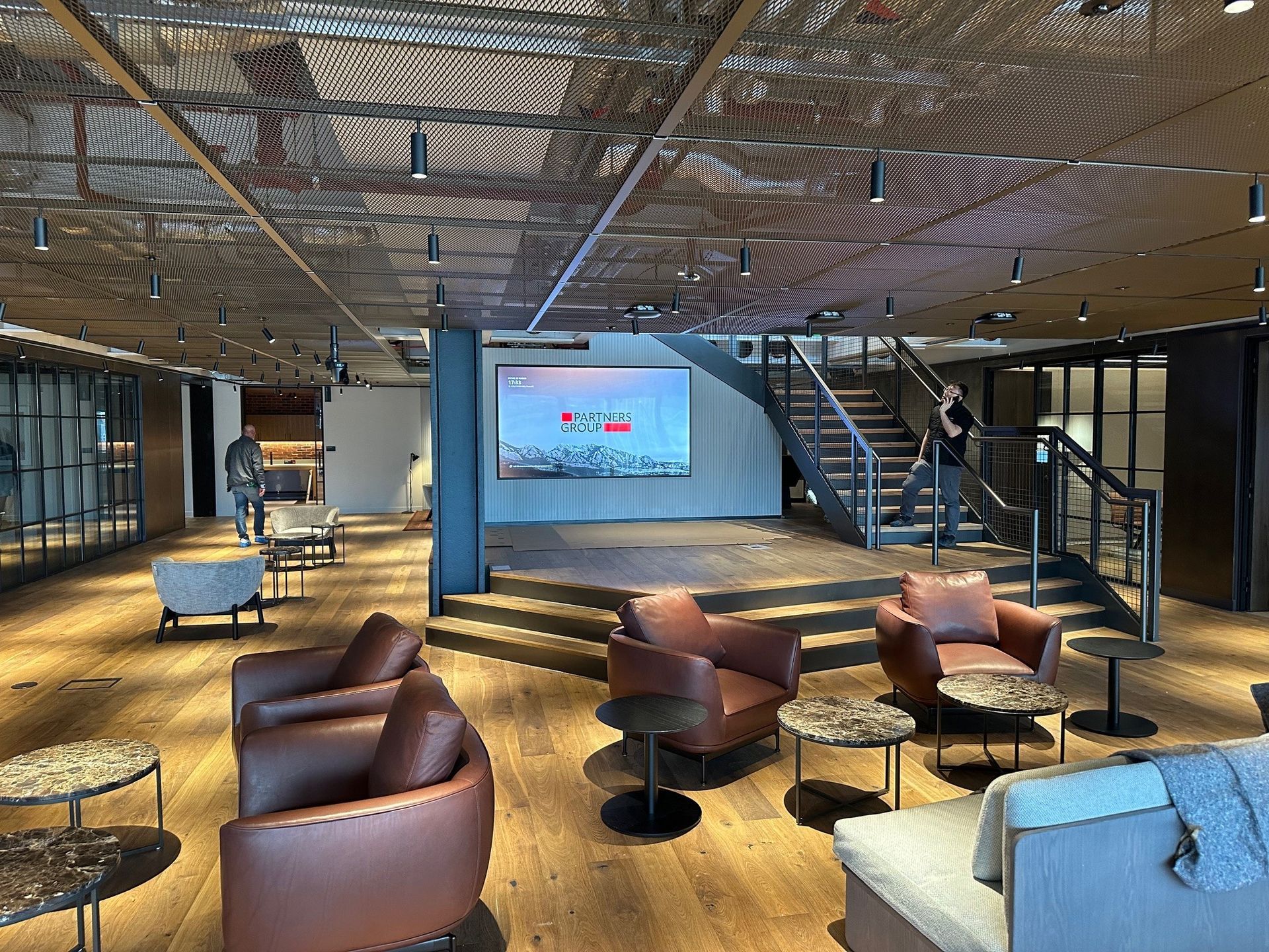 A large room with a lot of furniture and a large screen on the wall.