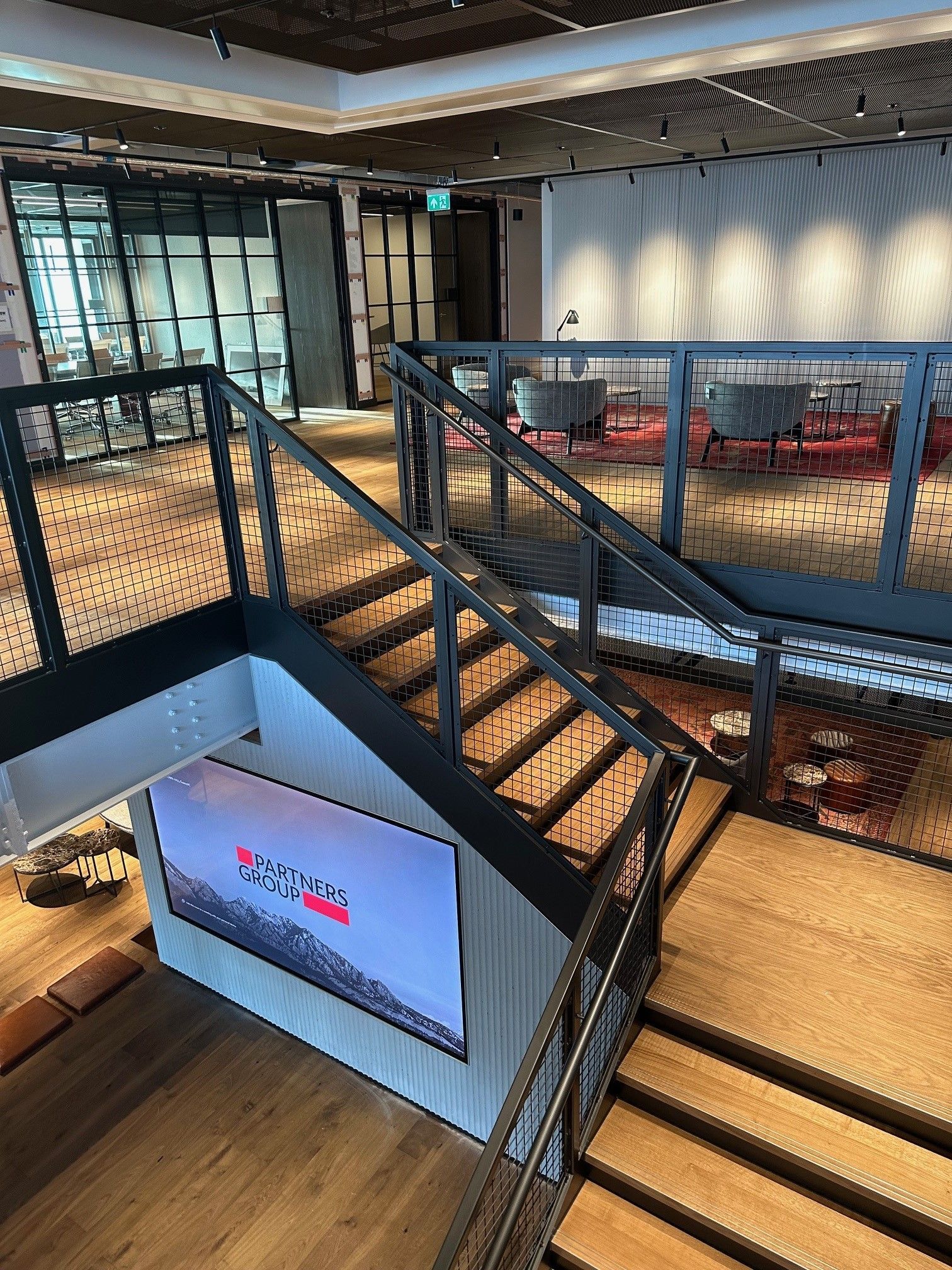 A Wooden Staircase with Metal Hand Railings A staircase in a building with metal hand railings