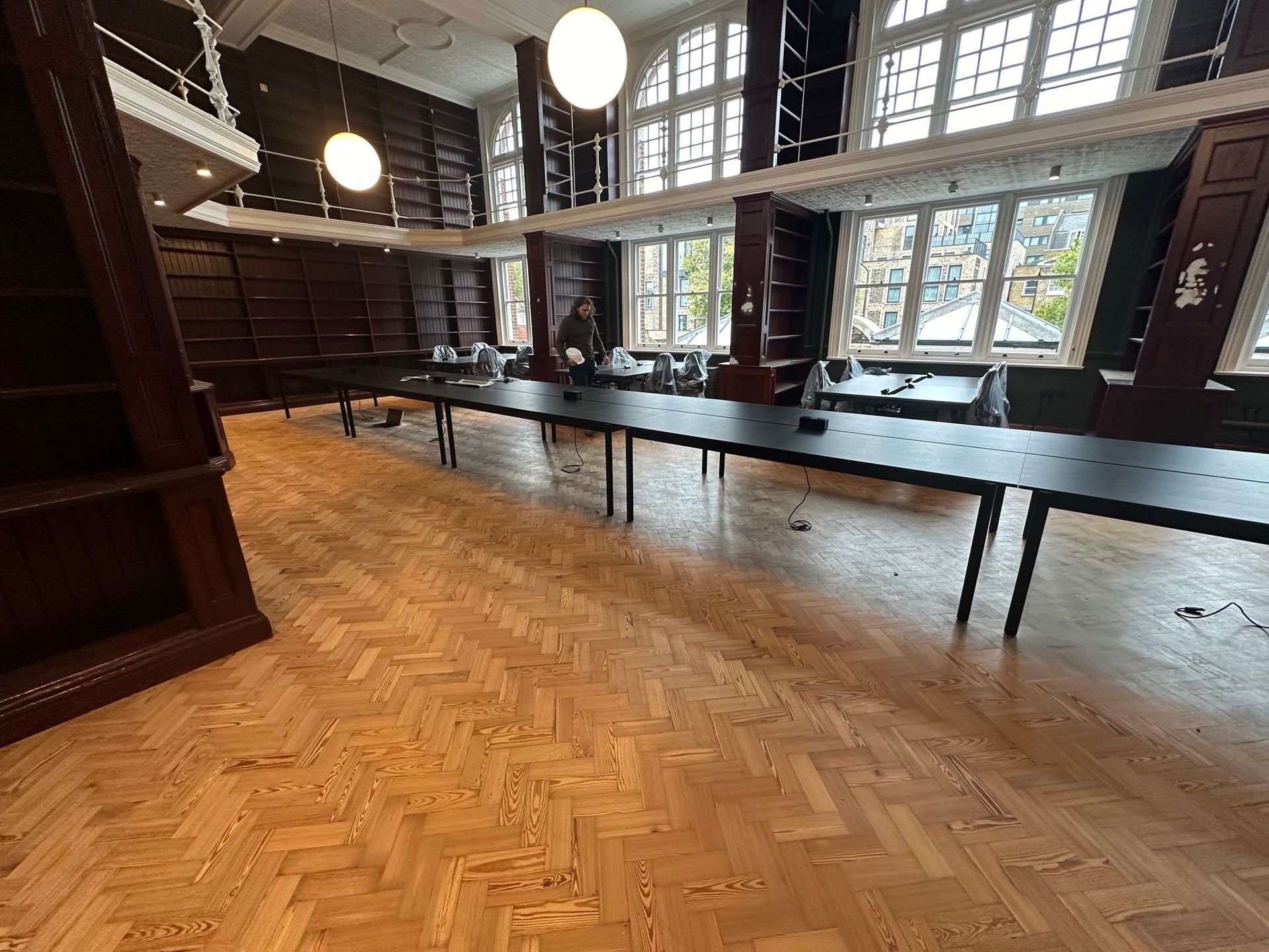A parquet floor with a line of banquet tables with a mezzainine above Walworth town hall