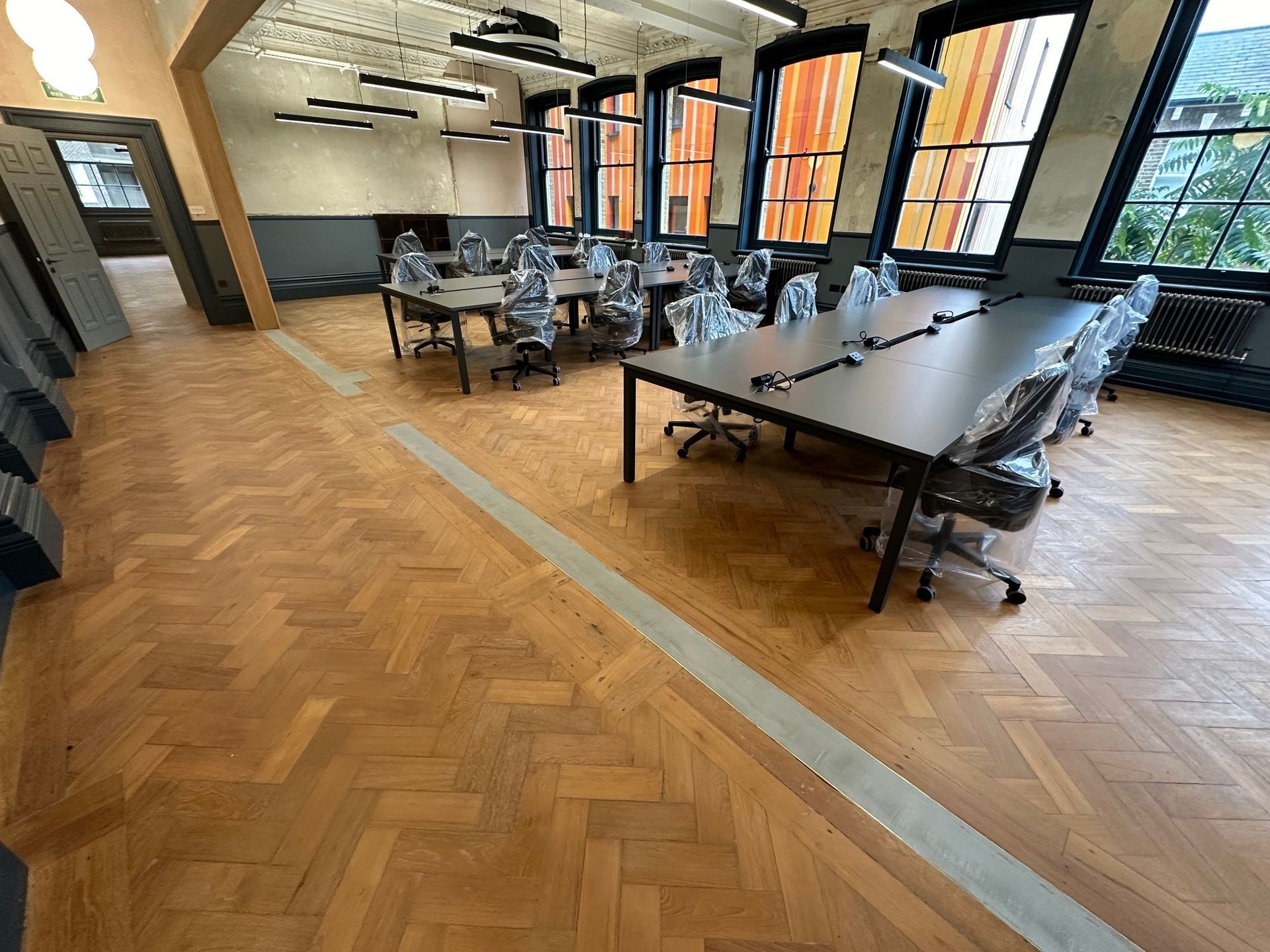  meeting tables in walworth town hall  with large windows and a wooden parquet floor 