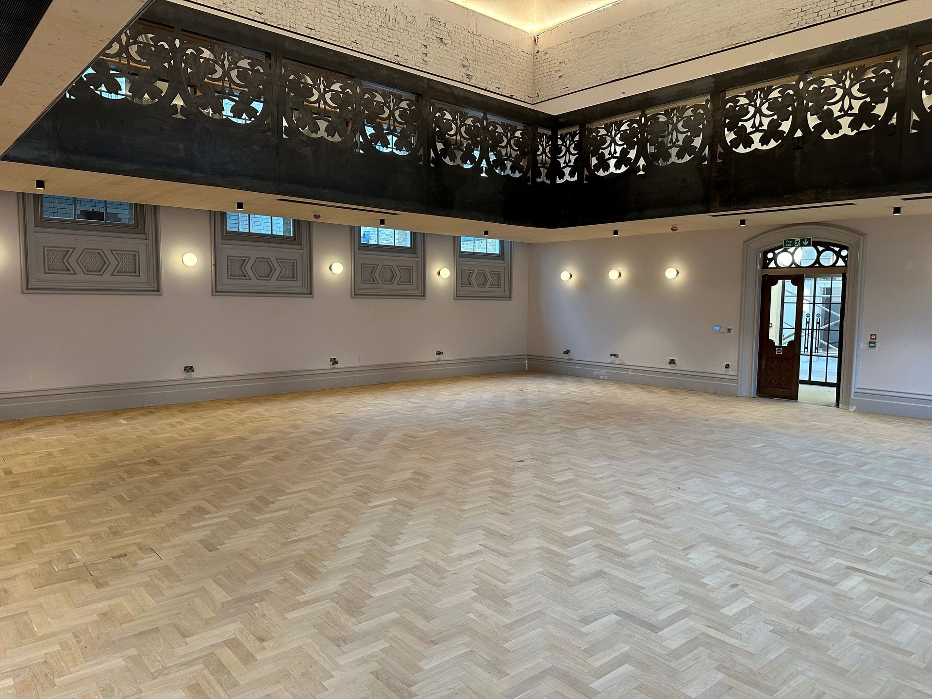 A large empty room with a wooden floor A large empty room with a wooden floor and a ceiling