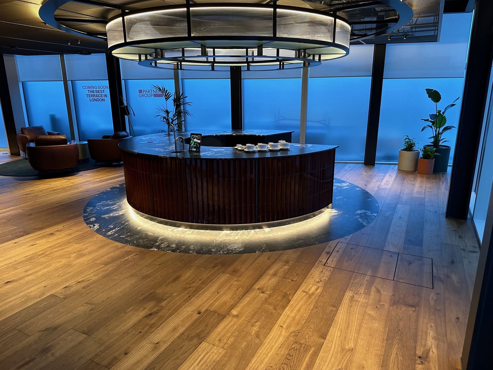 A large room with a wooden floor and a round bar.