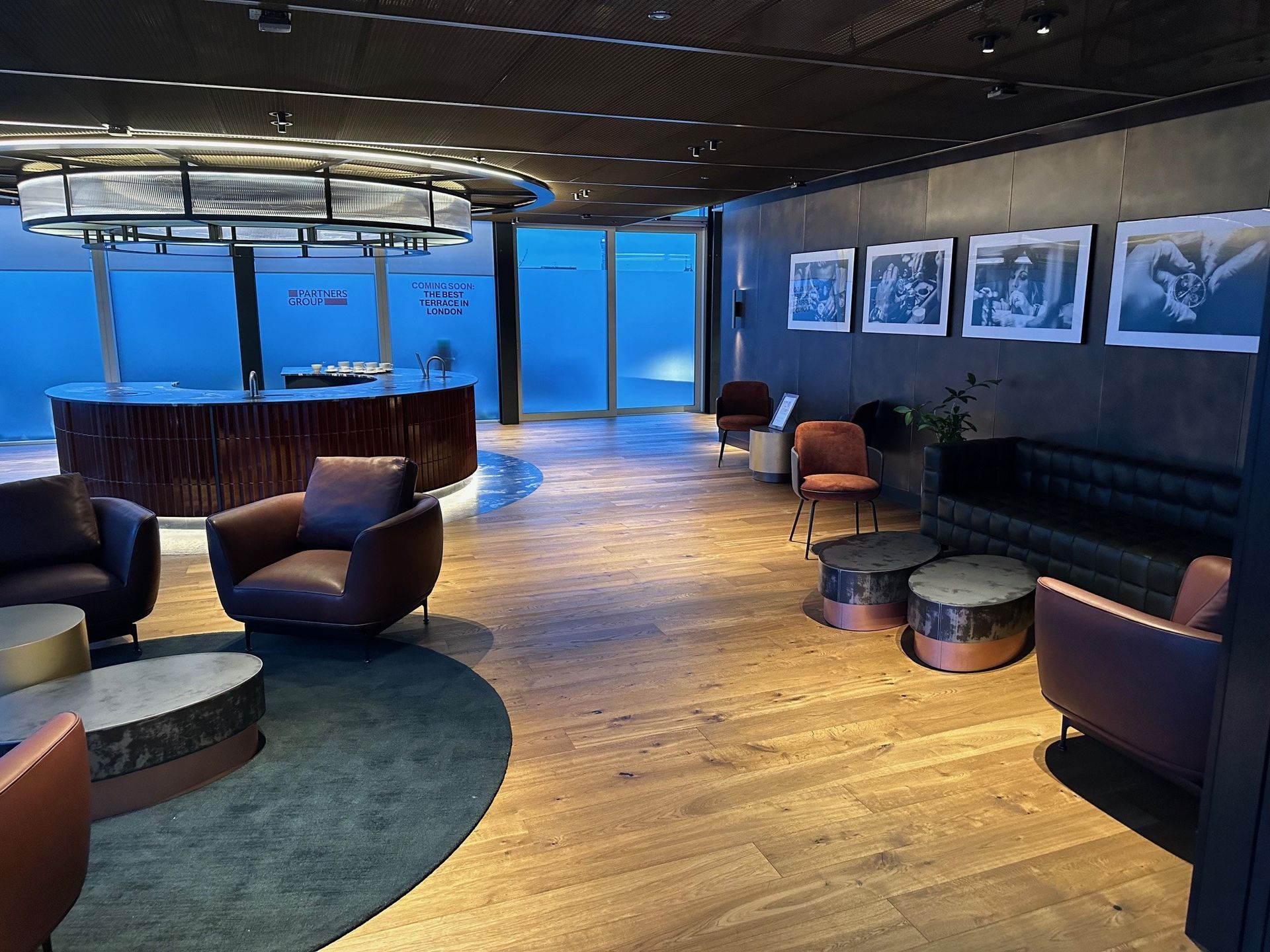 A living room with a couch , chairs , tables and a bar.