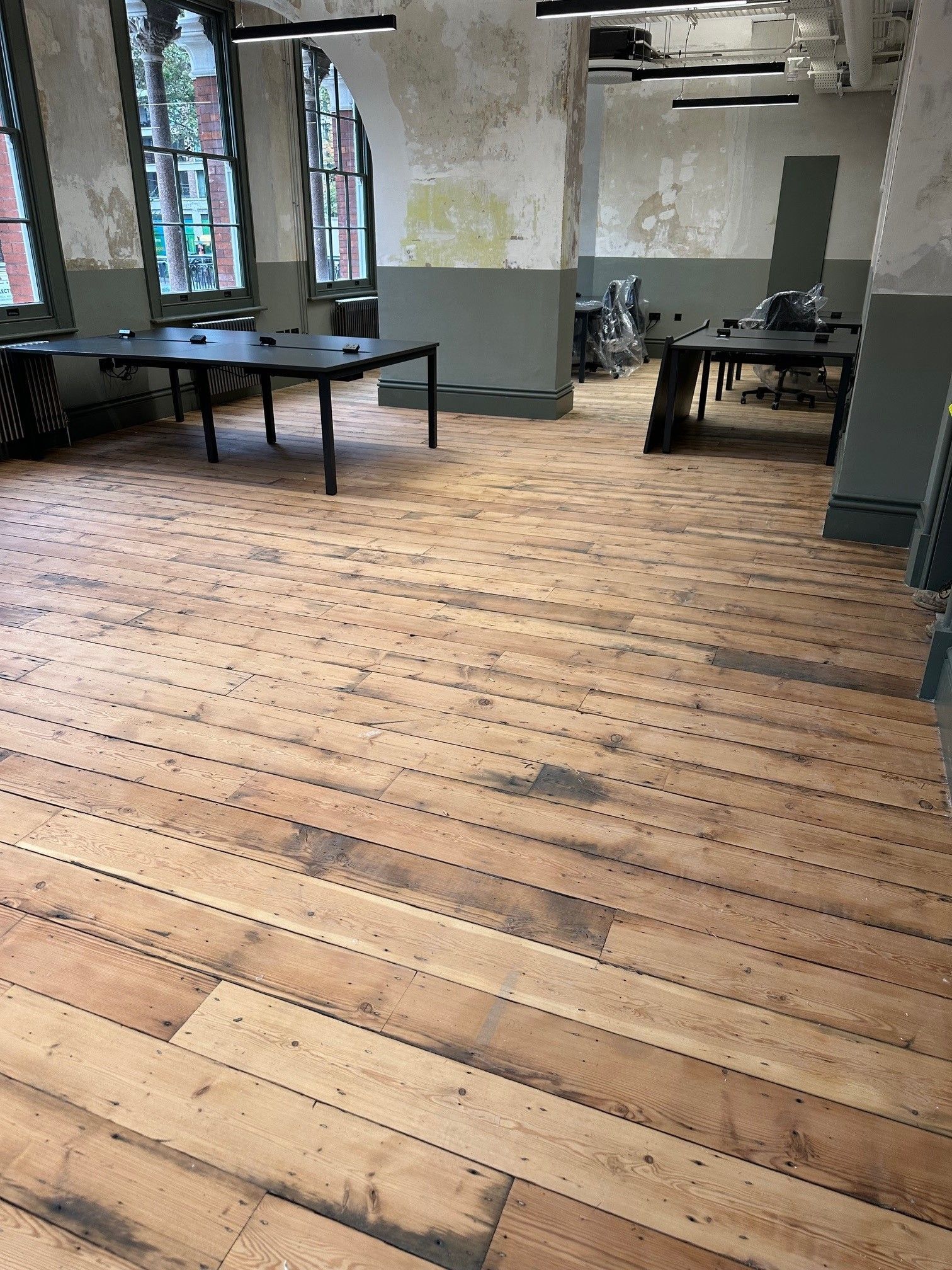 A large room with wooden floors and tables.