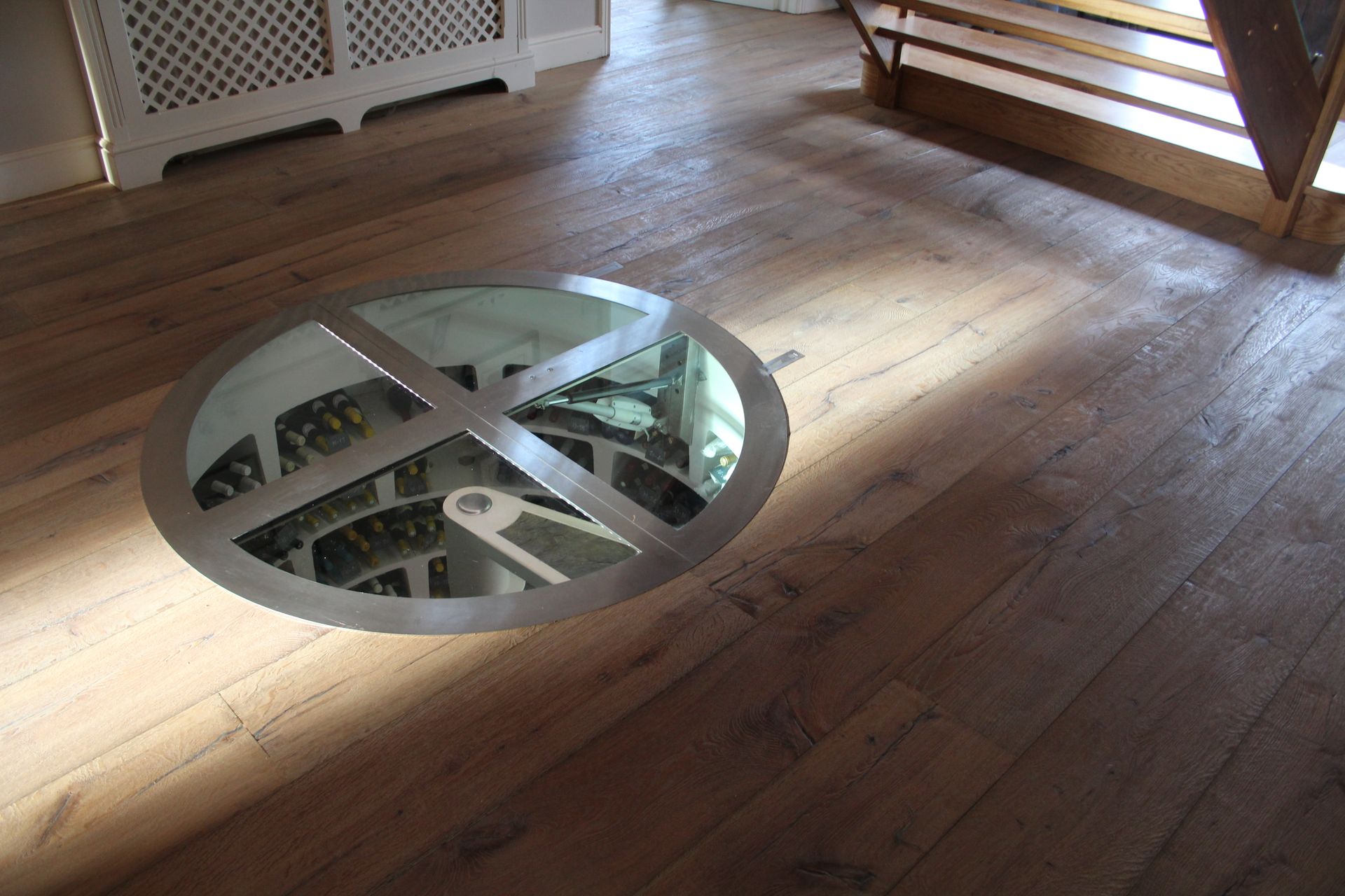 Wine cellar entrance under staircase surrounded by Mock Reclaimed Oiled Oak Flooring