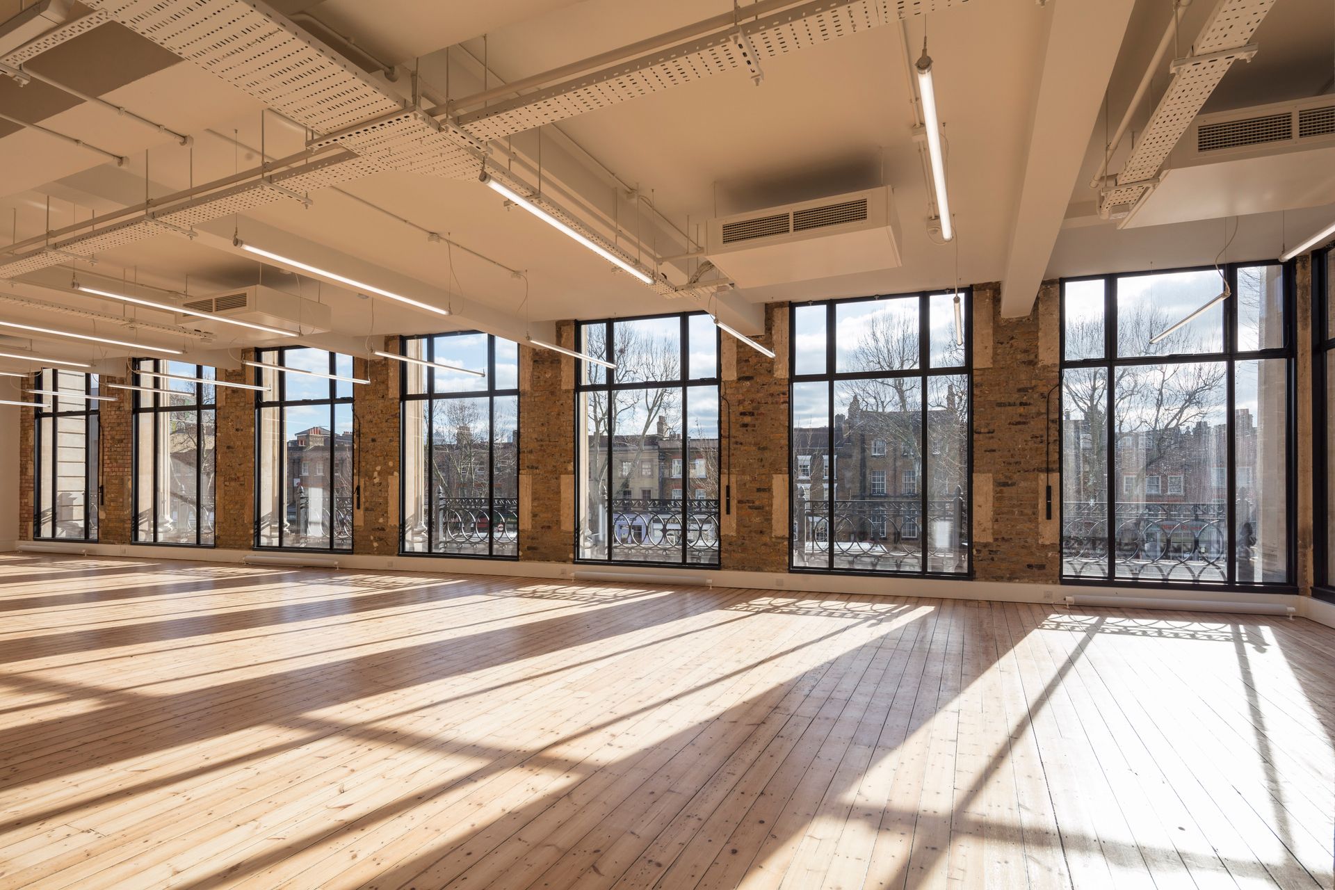 Clear Polyurethane Lacquer flooring in room with windows at Department W, East London