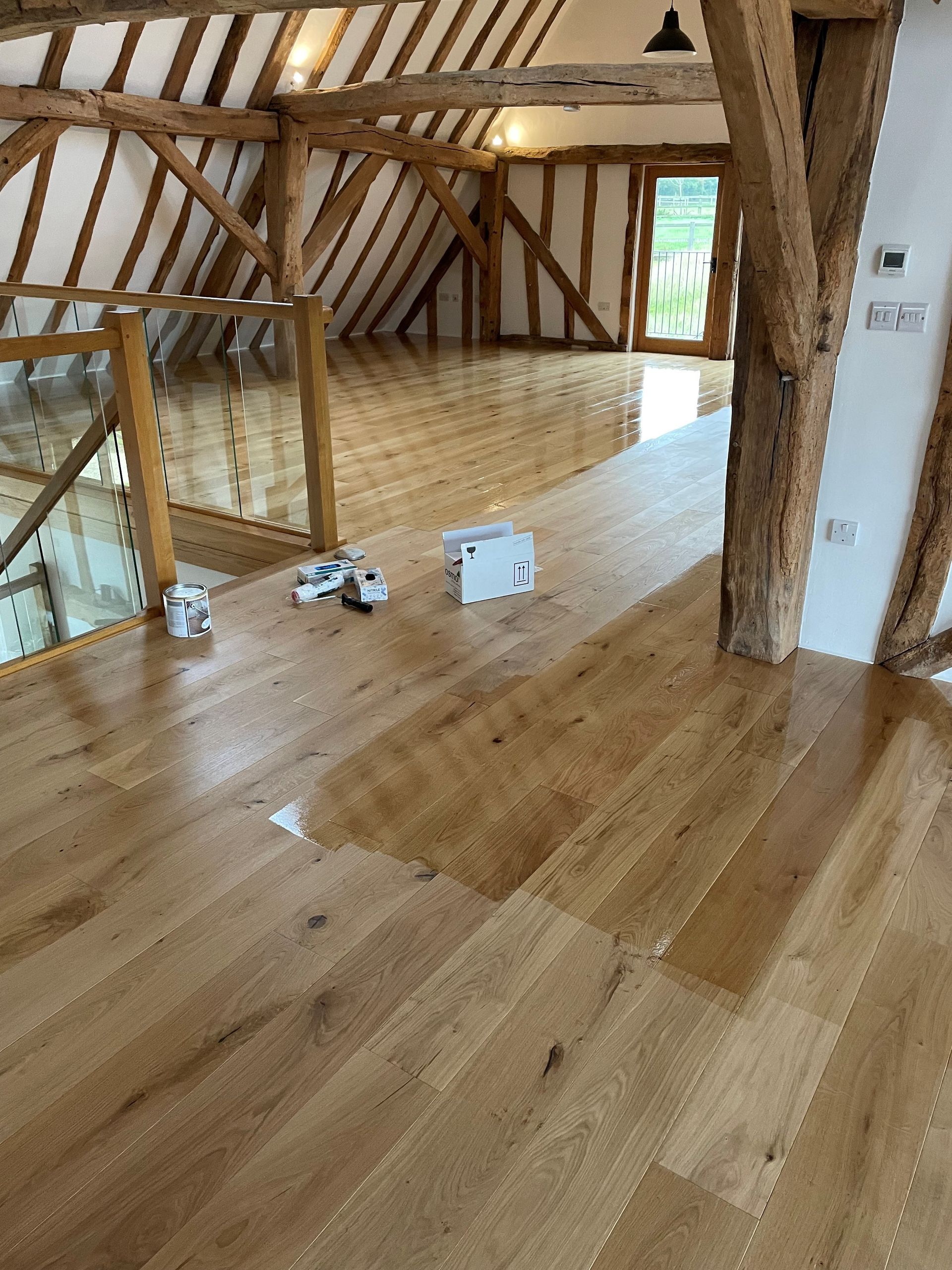 A room with a wooden floor and a staircase.
