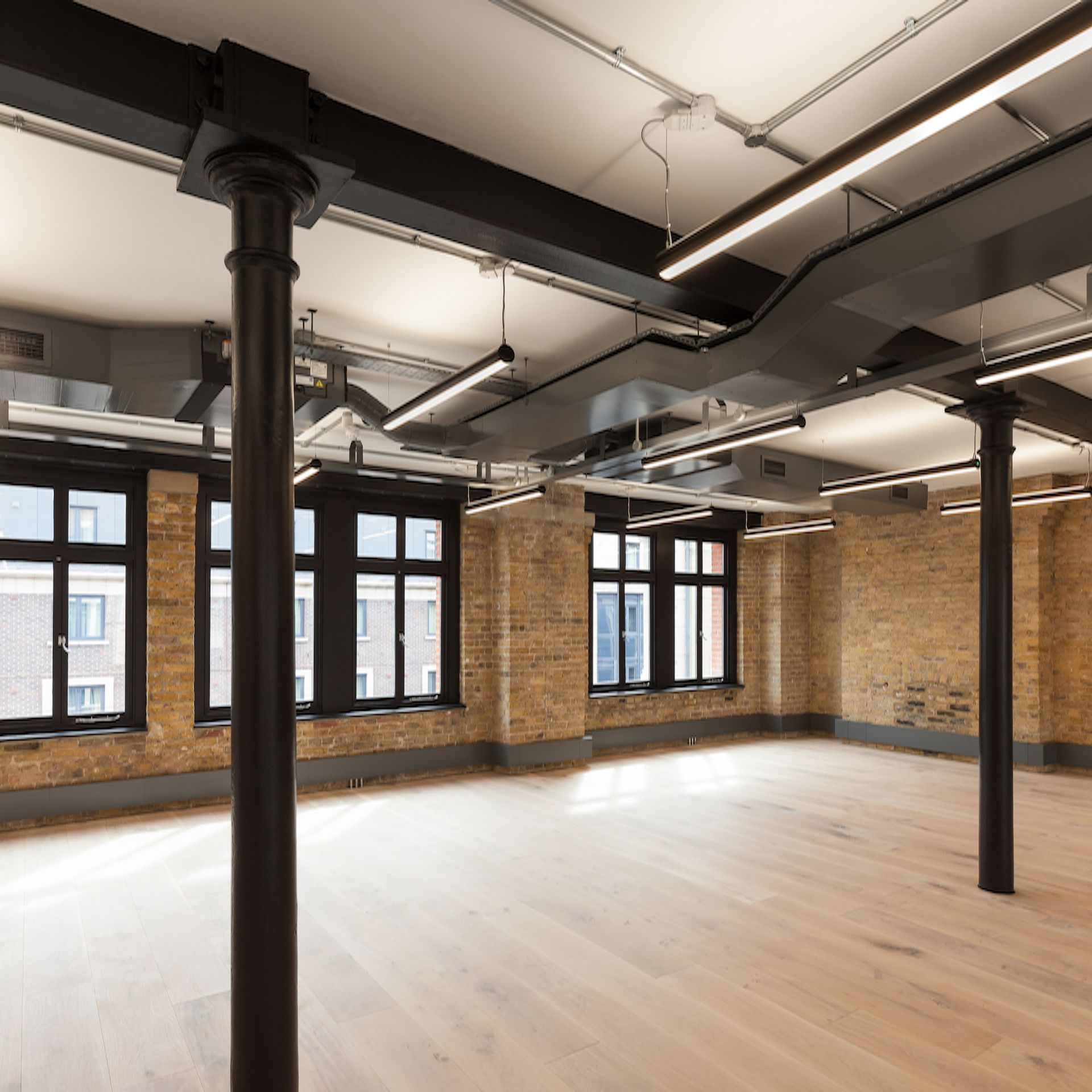 A large empty room with brick walls and wooden floors