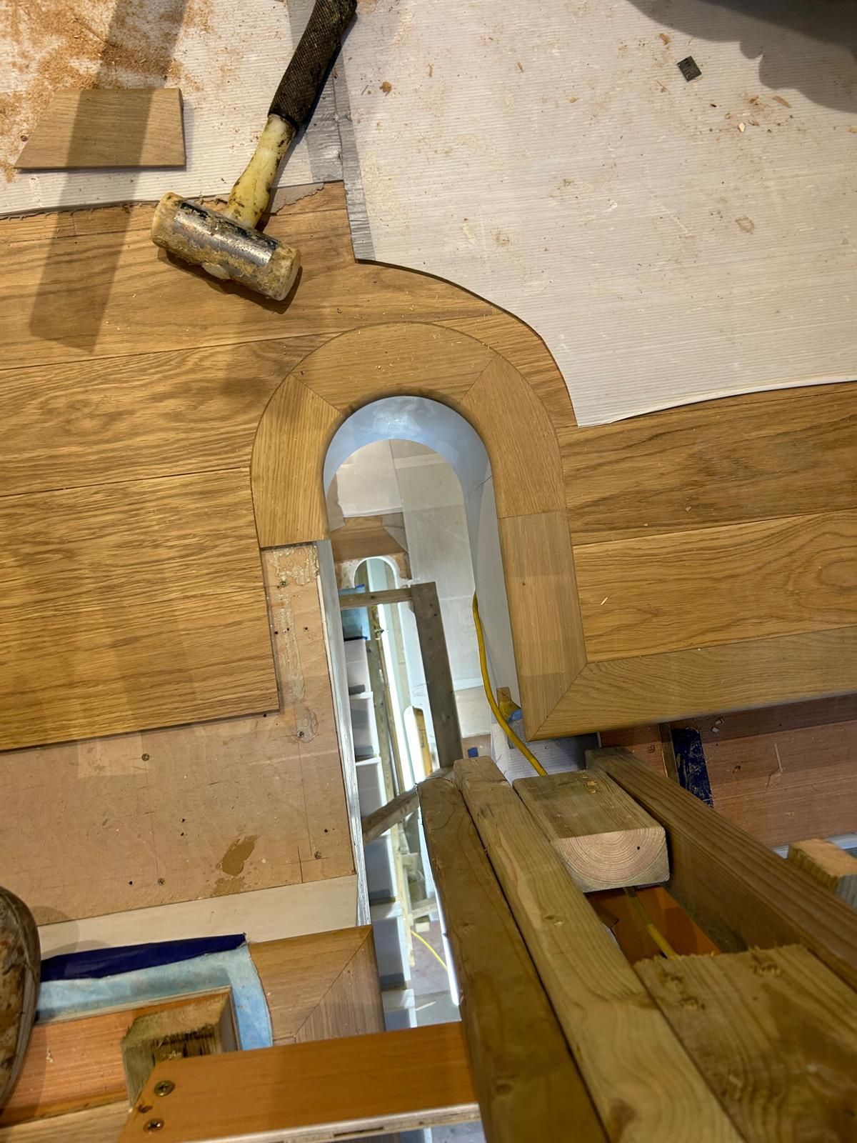 A hammer is sitting on top of a piece of wood.