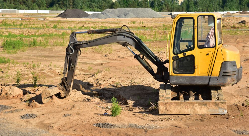 Yellow Excavator on a Construction Site, With Arm Extended — Brucic Construction in Queanbeyan, NSW