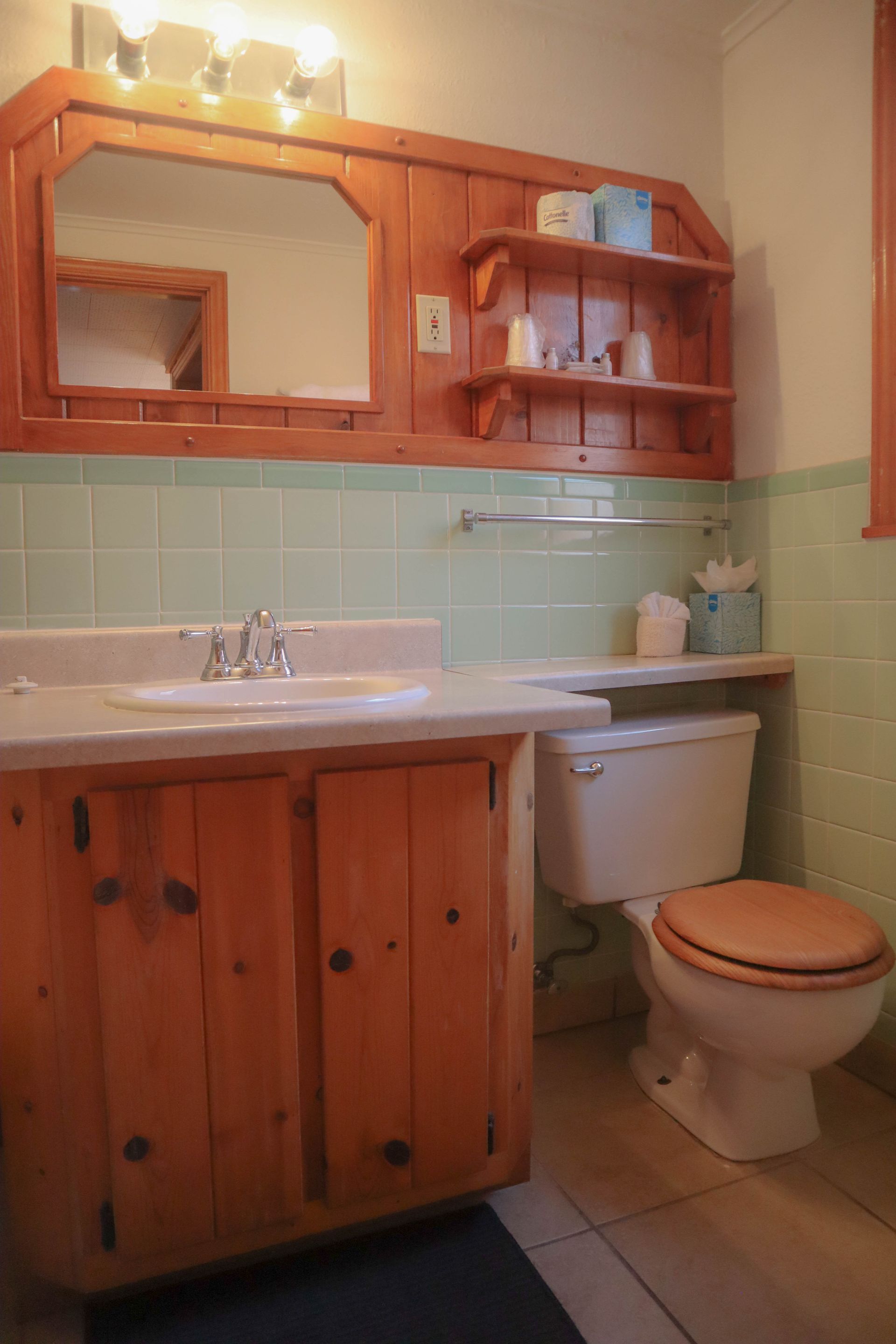 A bathroom with a sink , toilet and mirror.