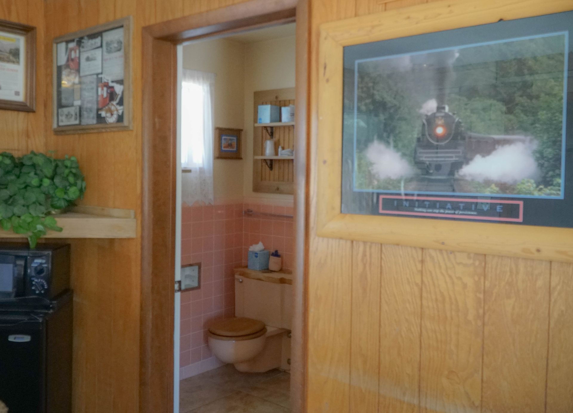 A bathroom with a picture of a train on the wall