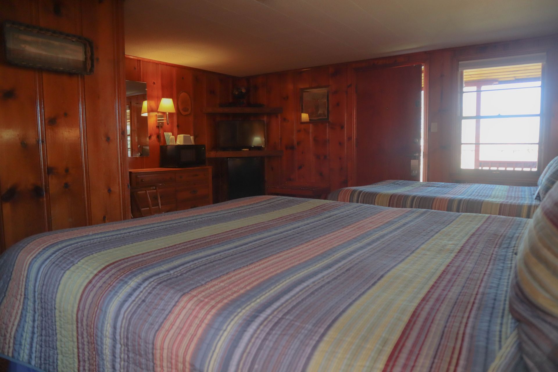 A hotel room with two beds and a fireplace.