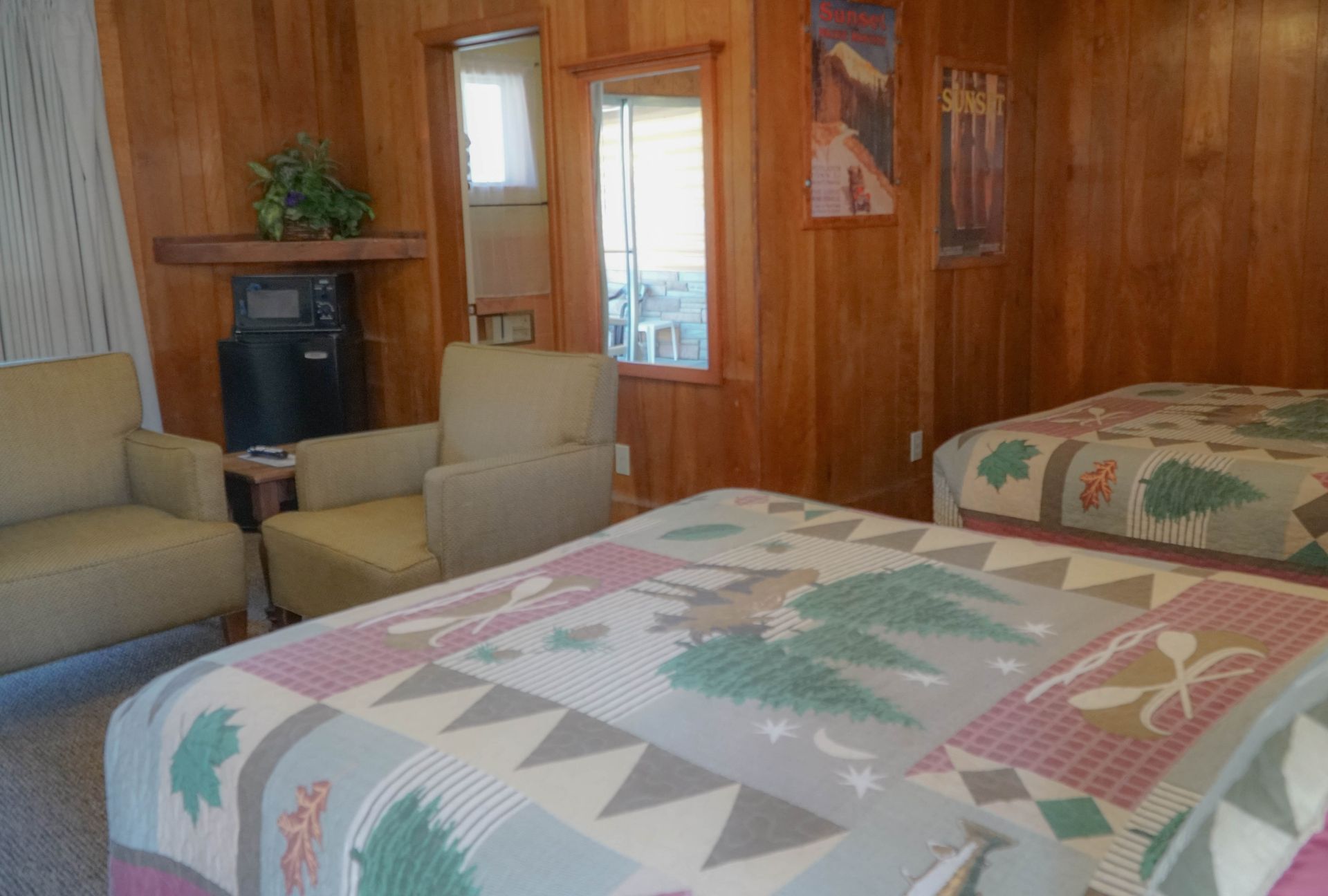 A hotel room with two beds , a chair and a mirror.