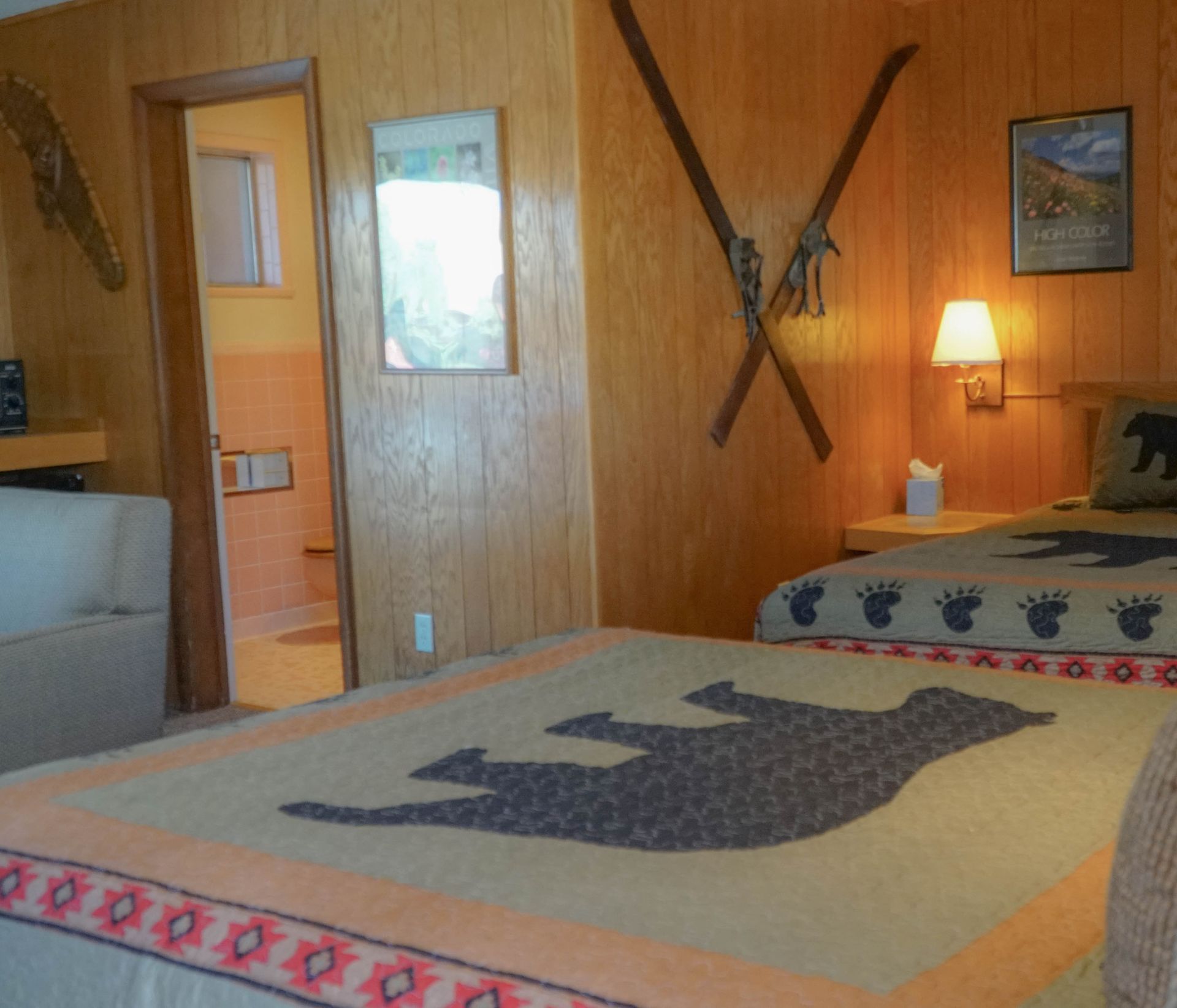 A bedroom with two beds and skis on the wall
