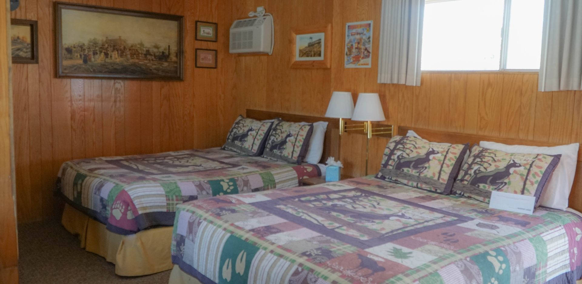 A hotel room with two beds and a window.
