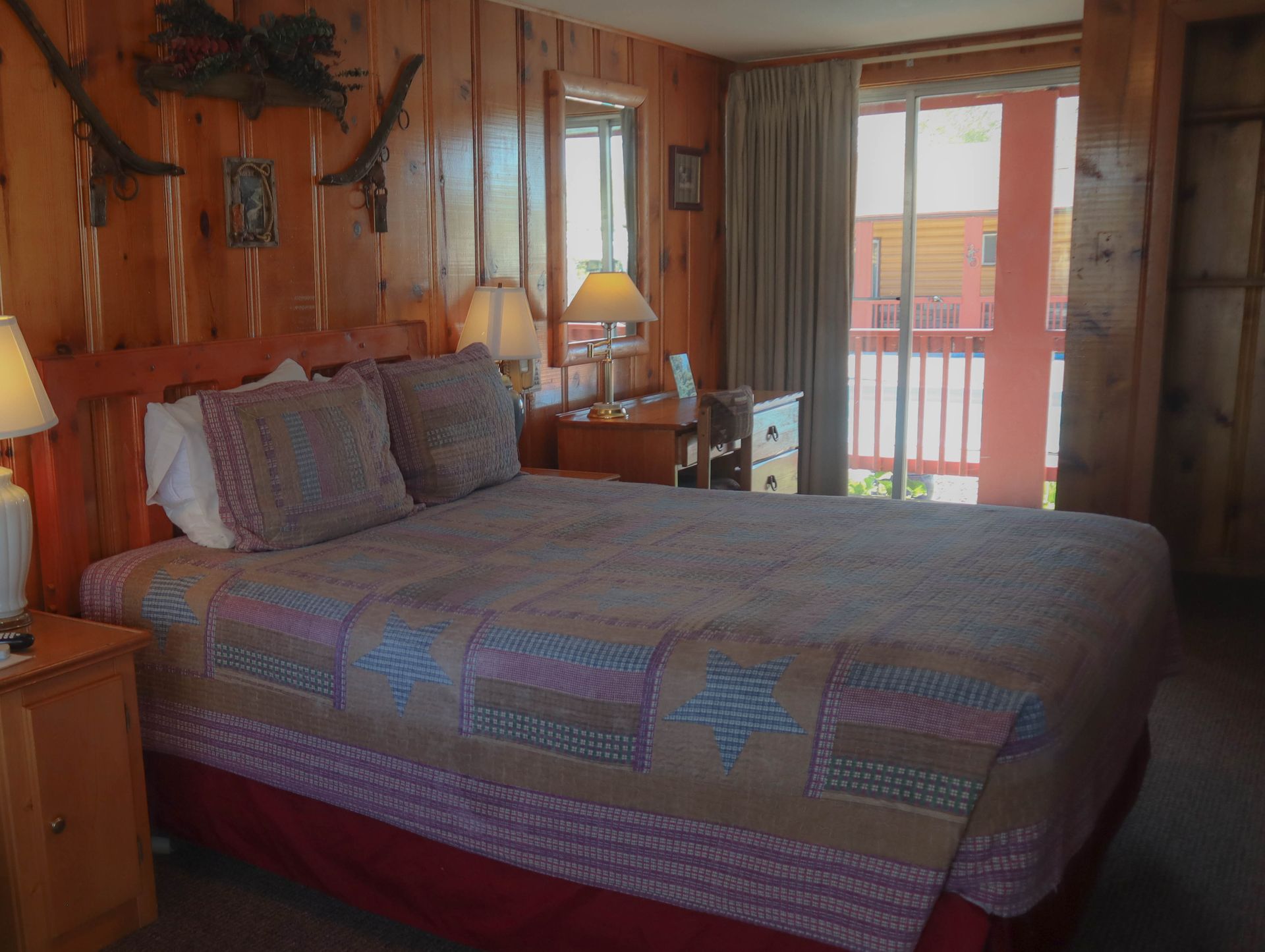 A hotel room with a king size bed and a sliding glass door