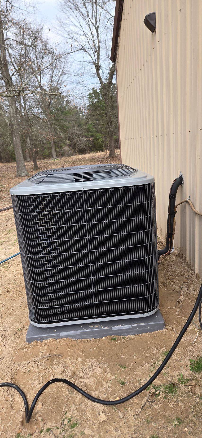 A large air conditioner is sitting outside of a building.