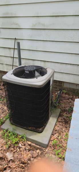 An air conditioner is sitting outside of a house.
