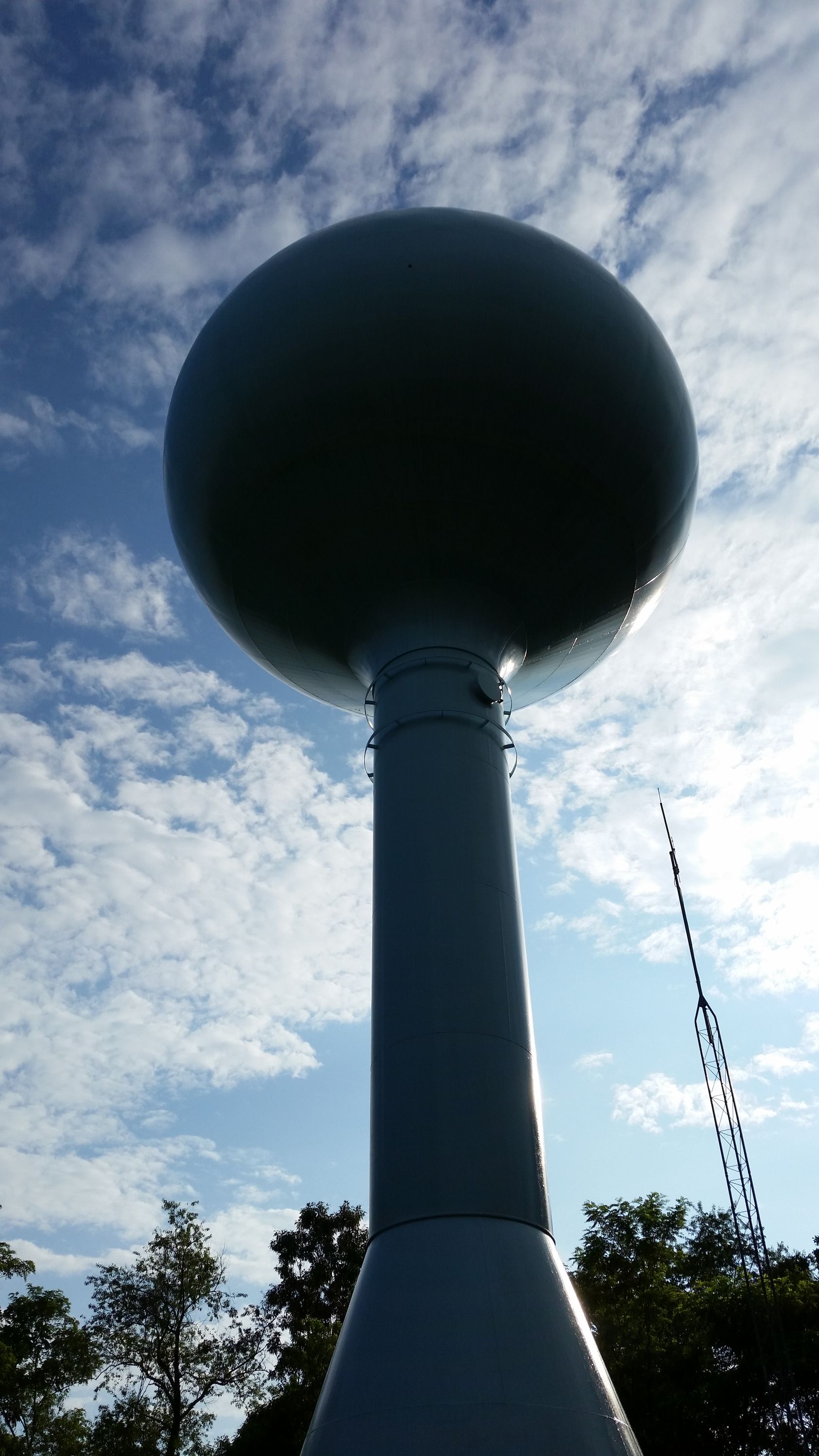 A water tower with a blue sky in the background