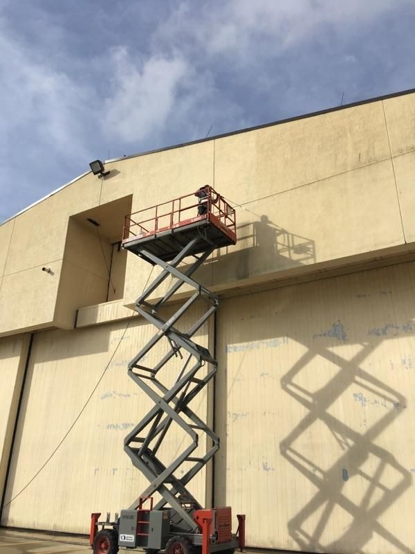 A scissor lift is parked in front of a building