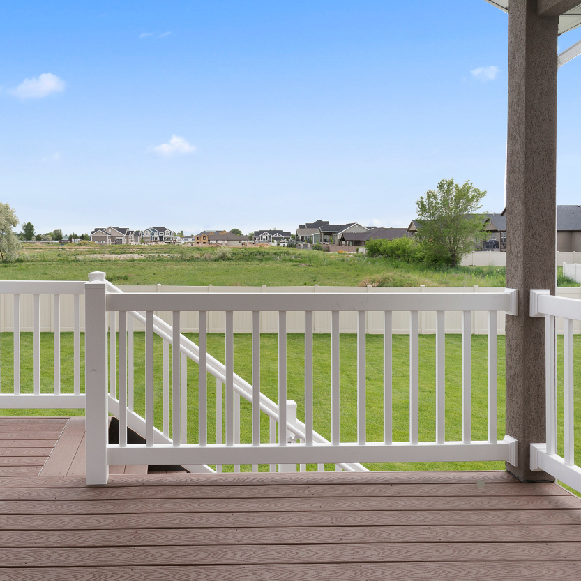An empty porch with a white railing and a view of a field in Baltimore, MD