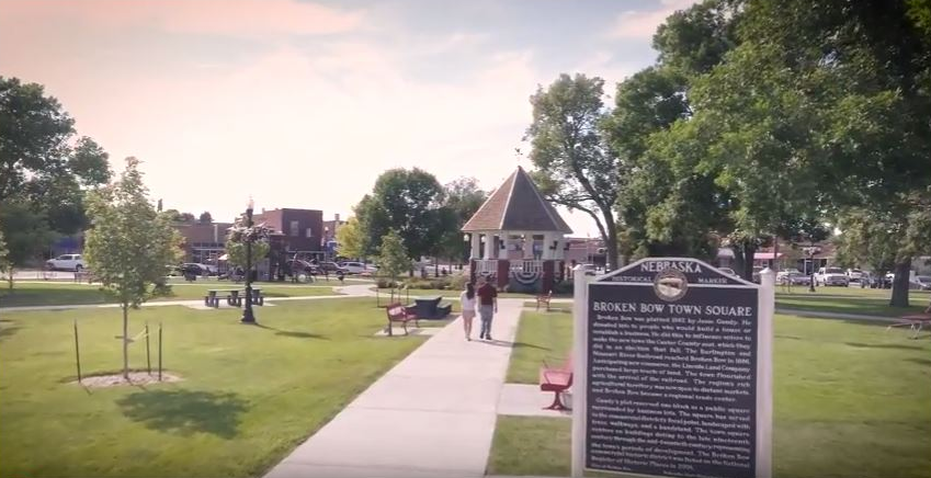 A couple walking down a sidewalk in a park