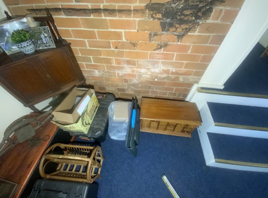 A Room With A Brick Wall , Stairs , And A Lot Of Furniture — Able Building and Pest Inspections In Bellingen, NSW
