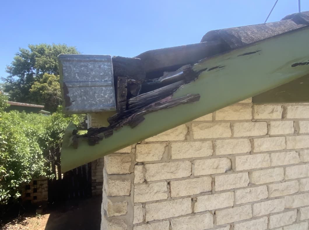 A Brick Building With A Green Gutter On The Side Of It — Able Building and Pest Inspections In Bellingen, NSW