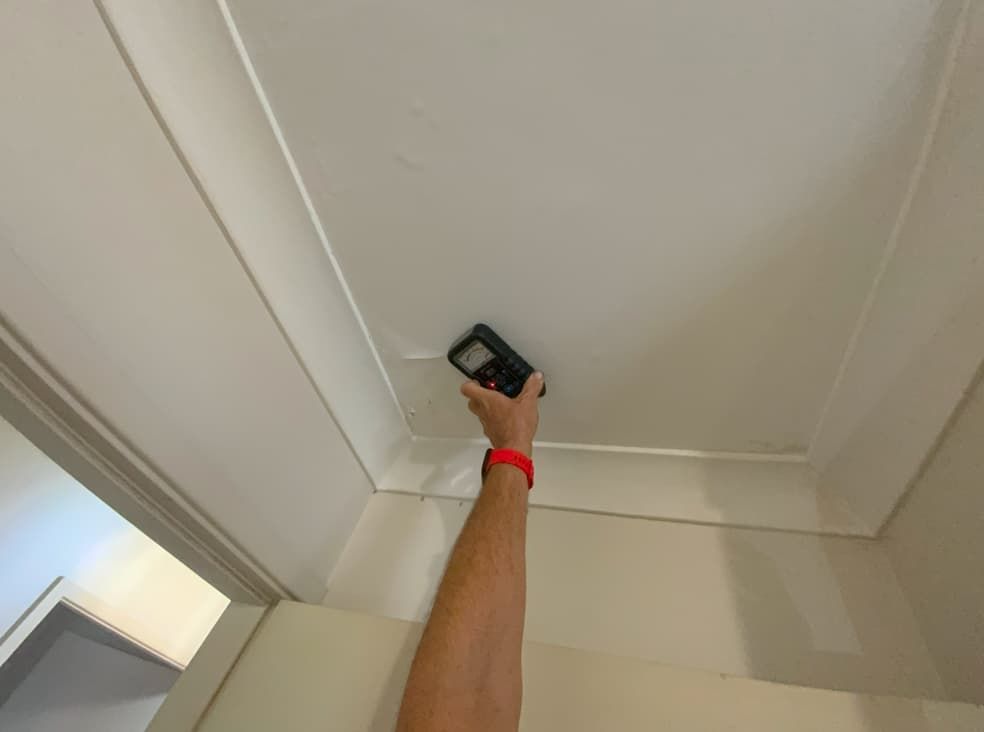 A Person Is Measuring The Ceiling With A Tape Measure — Able Building and Pest Inspections In Coffs Harbour, NSW