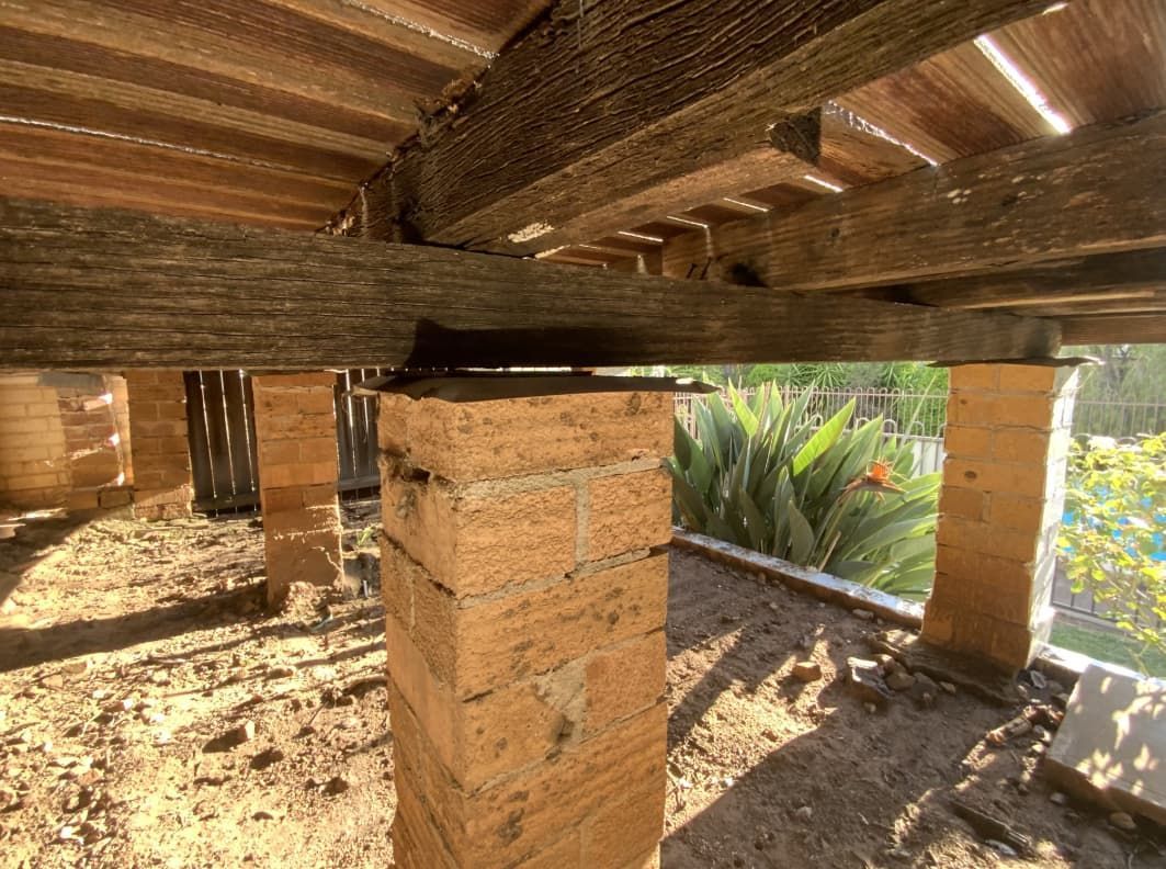 A Brick Column Is Sitting Under A Wooden Deck — Able Building and Pest Inspections In Coffs Harbour, NSW