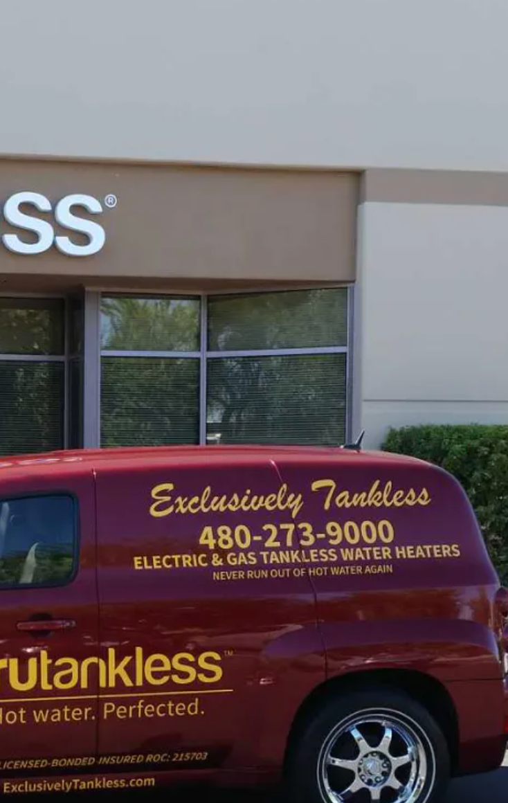 A red van is parked in front of a building that says exclusively tankless