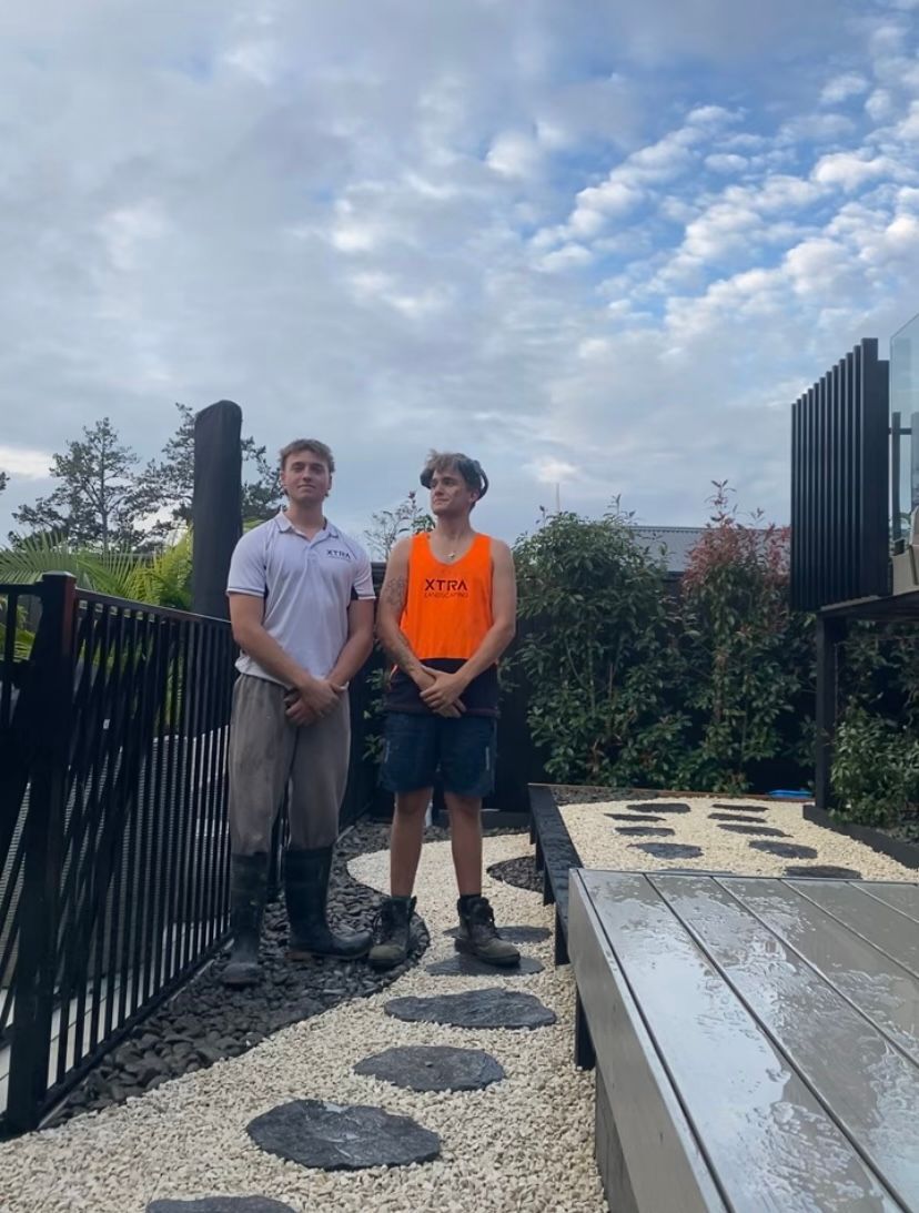 Two men are standing next to each other in a garden.