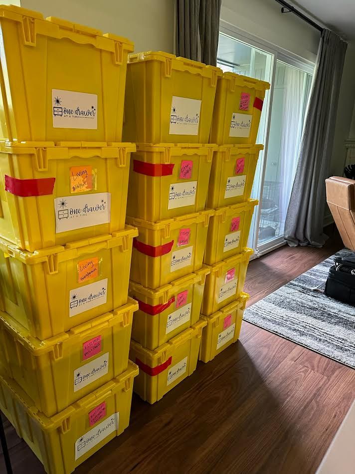 Stack of yellow storage bins with labels in a room.