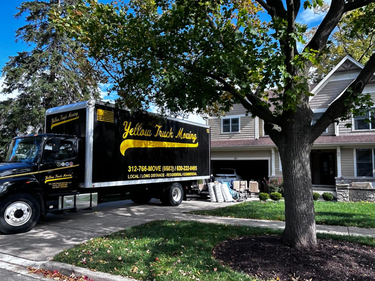 Yellow Truck Moving truck parked in front of a house on a sunny day.