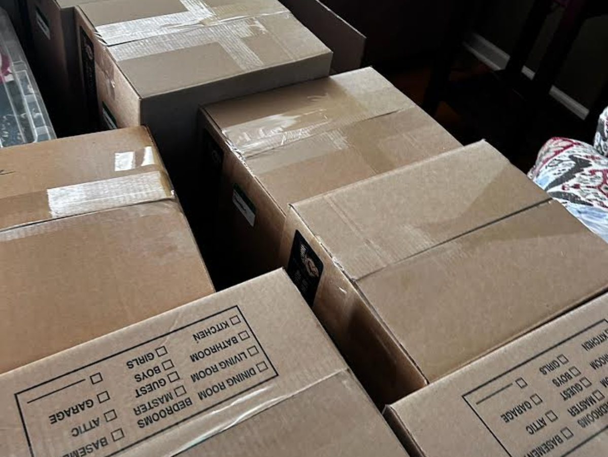 Cardboard boxes, taped closed, stacked inside a room.