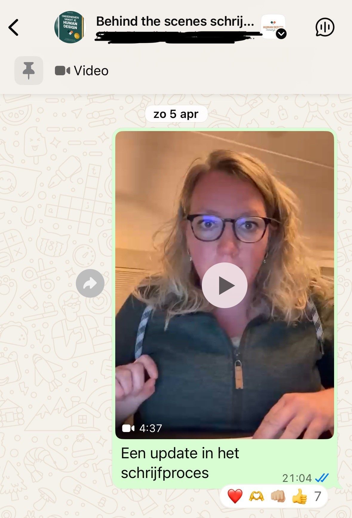 Vrouw in paarse jumpsuit, met bril, staat achter een podium en spreekt. Presentatie op de achtergrond.