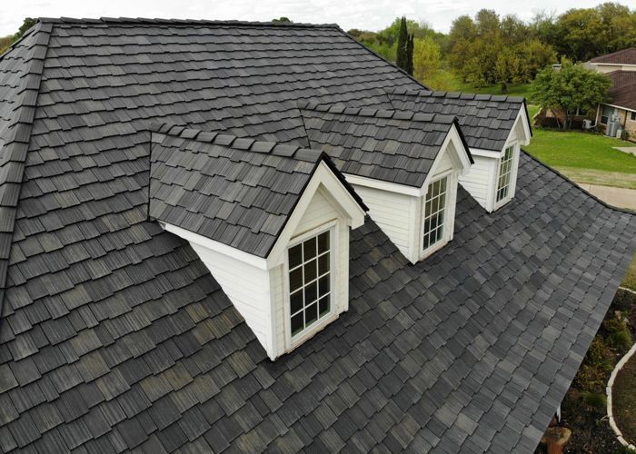 An aerial view of a house with a gray roof and white windows.