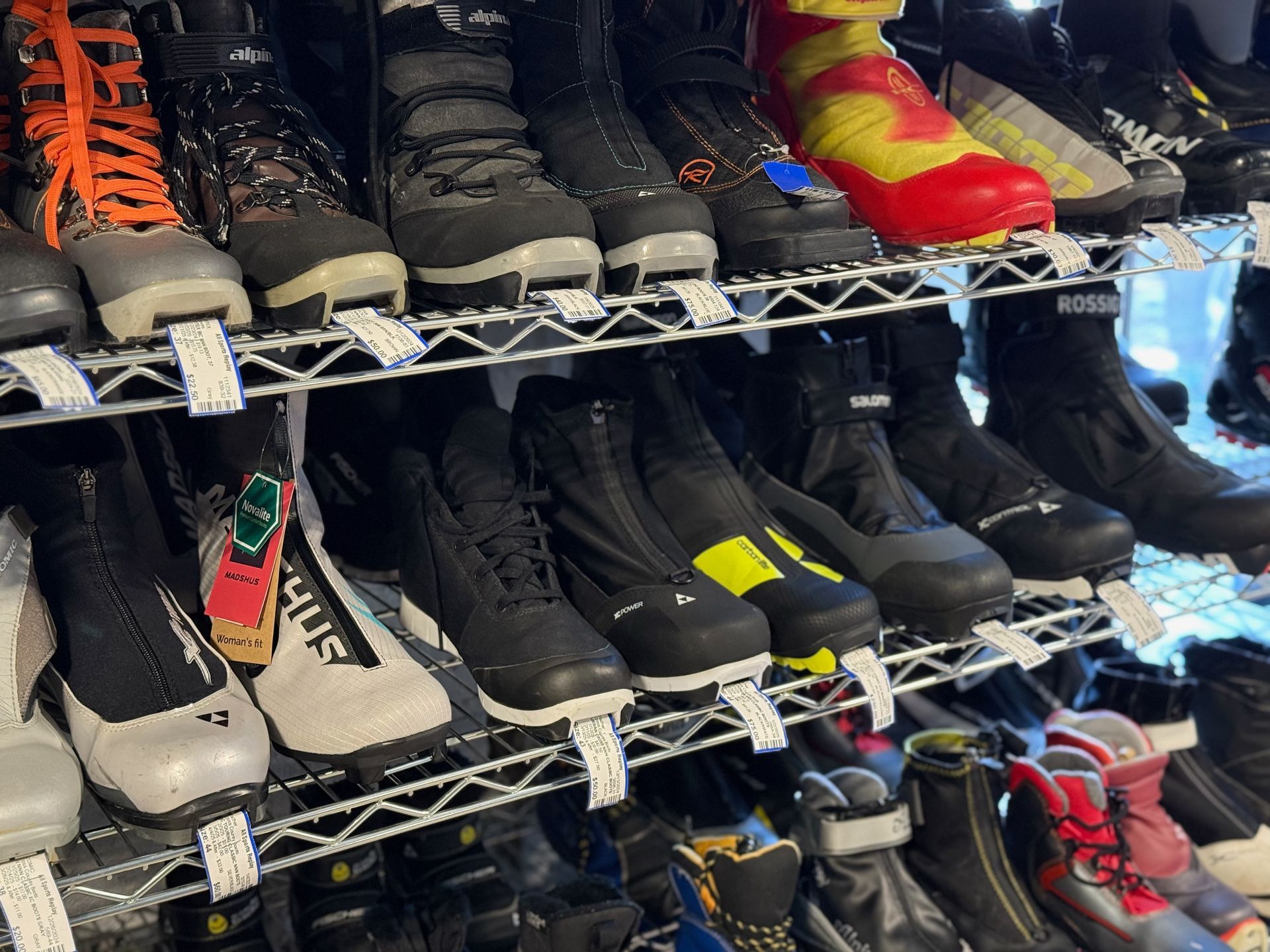 A bunch of boots are lined up on a shelf in a store