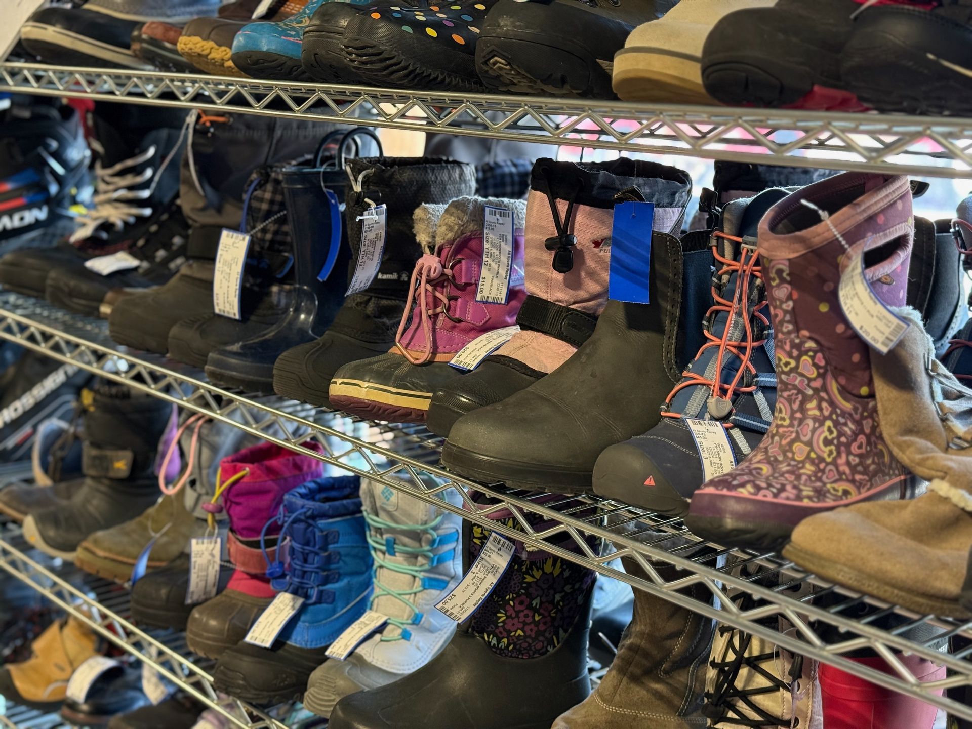 A shelf filled with lots of different types of boots.