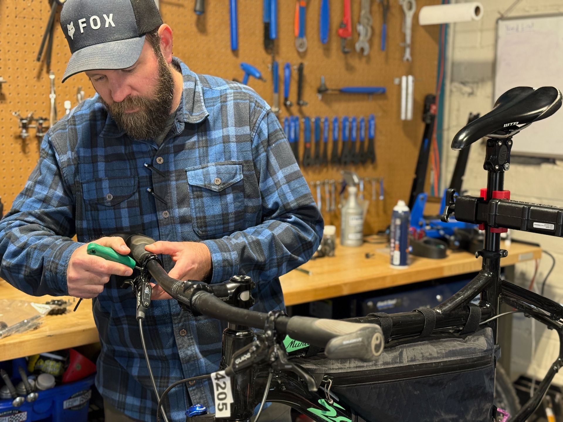 A man is working on a bicycle in a workshop.