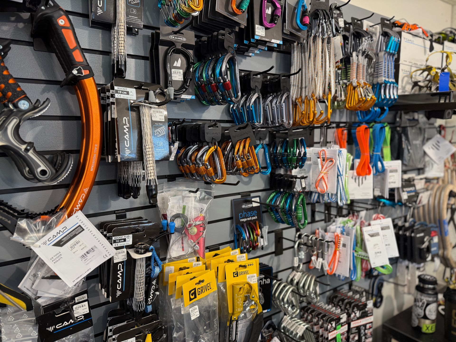 A row of skis and snowboards are lined up on display in a store.