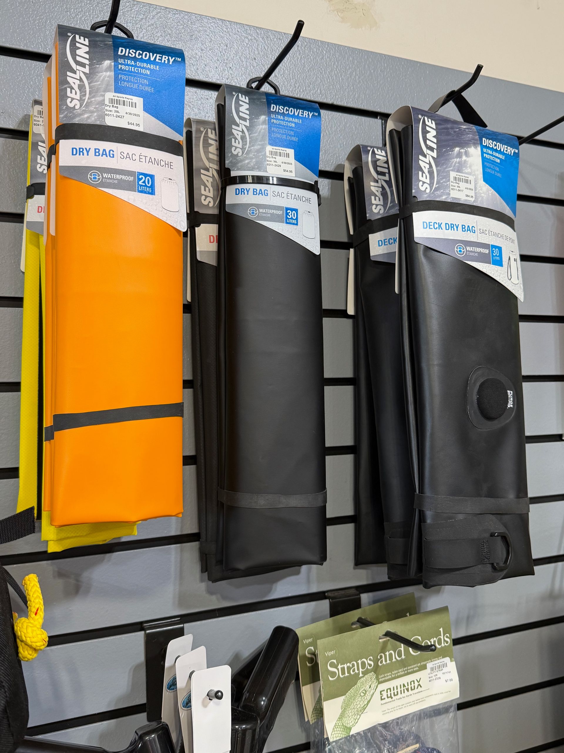 A row of skis and snowboards are lined up on display in a store.