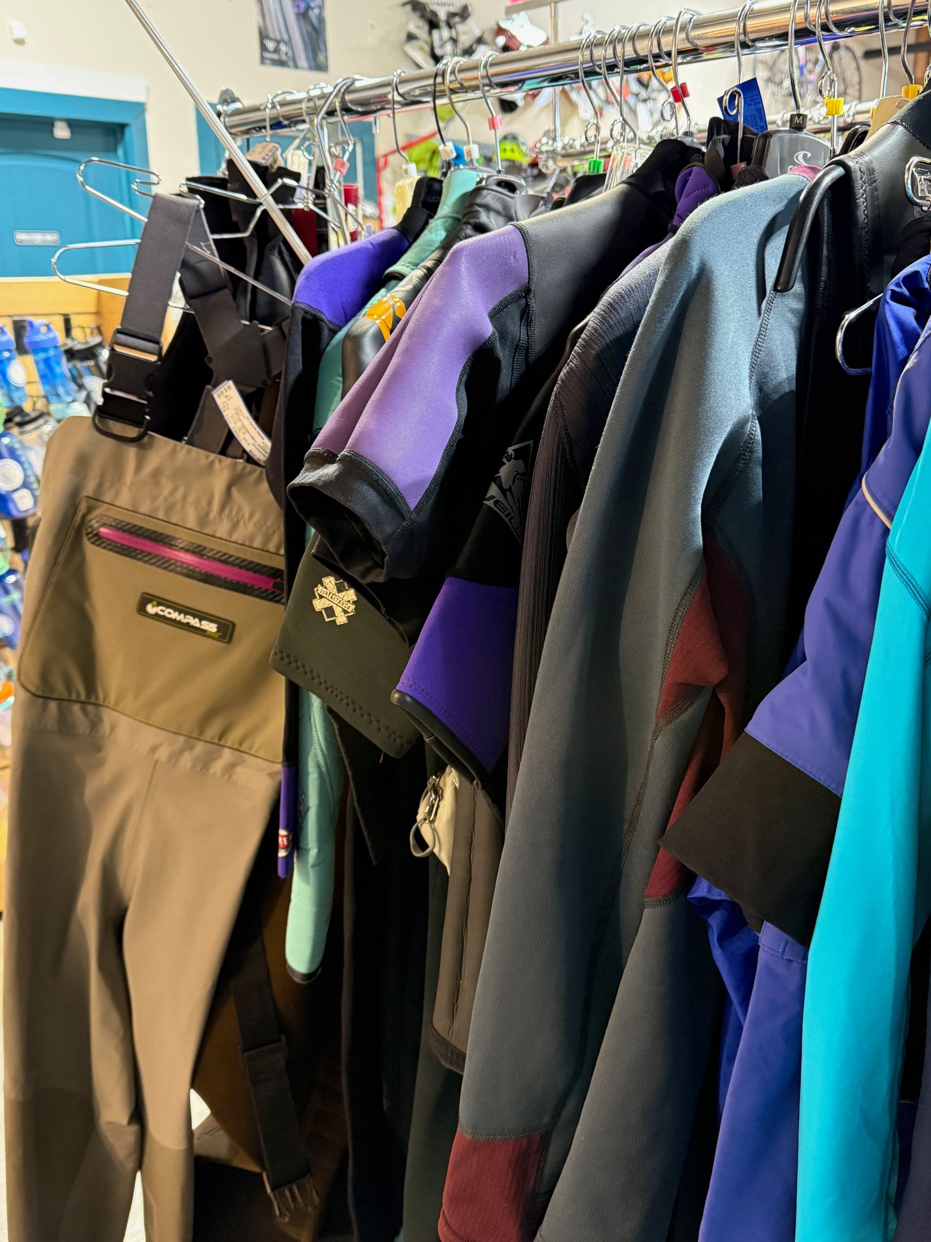 A row of skis and snowboards are lined up on display in a store.