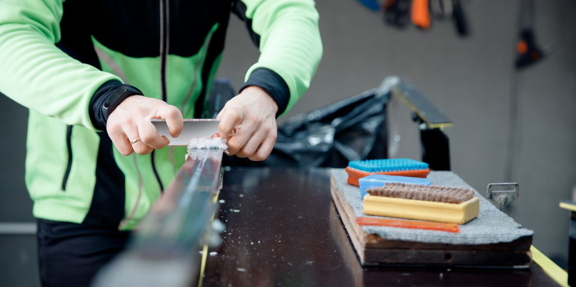 A person is sharpening a ski pole on a table.