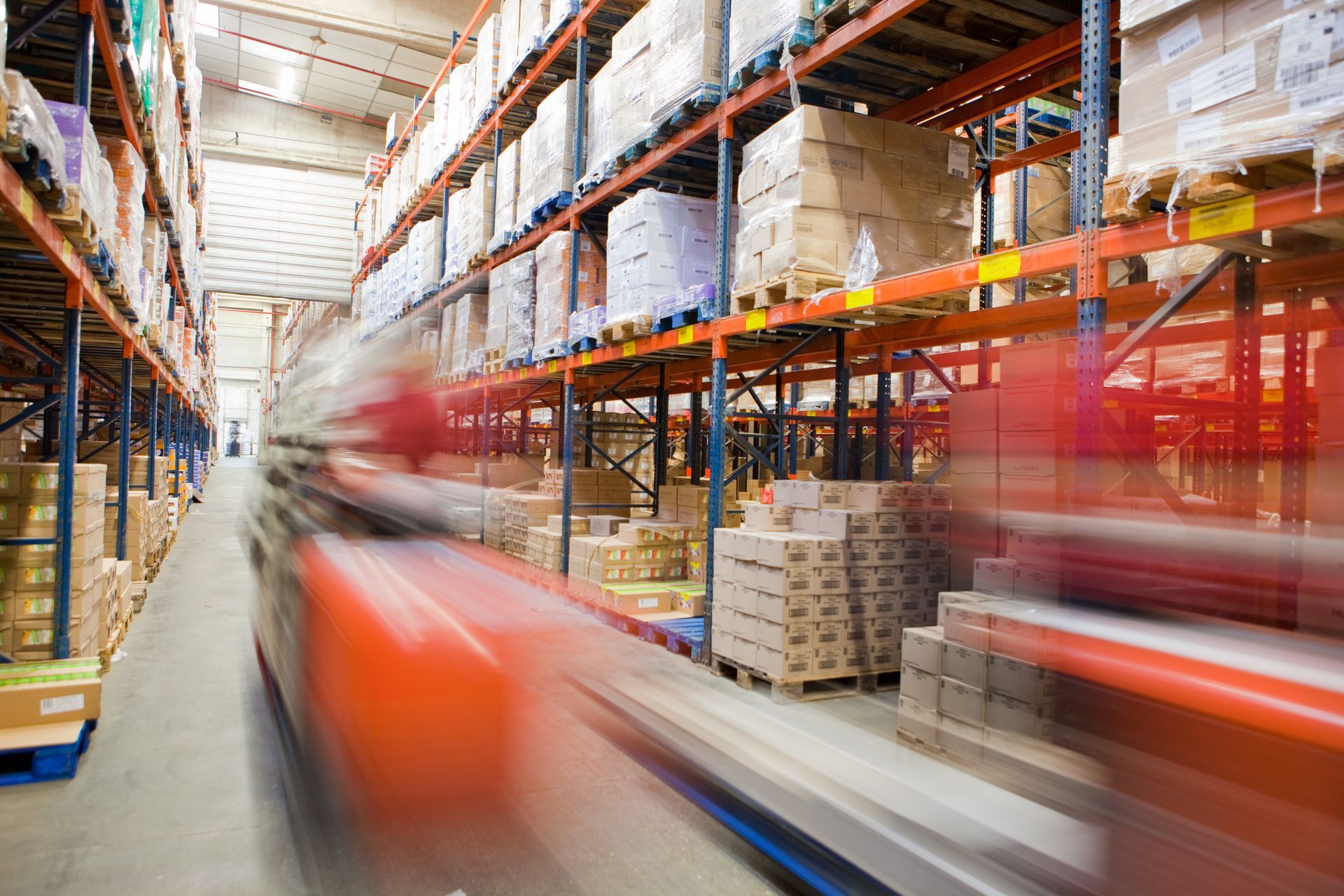 Fast-paced logistic services in a busy warehouse with a blurred forklift moving goods. Fast-paced logistic services in a busy warehouse with a blurred forklift moving goods.