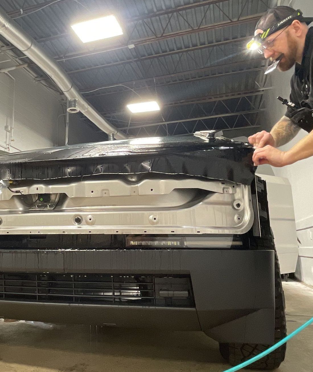 A man is applying window tinting to a car door