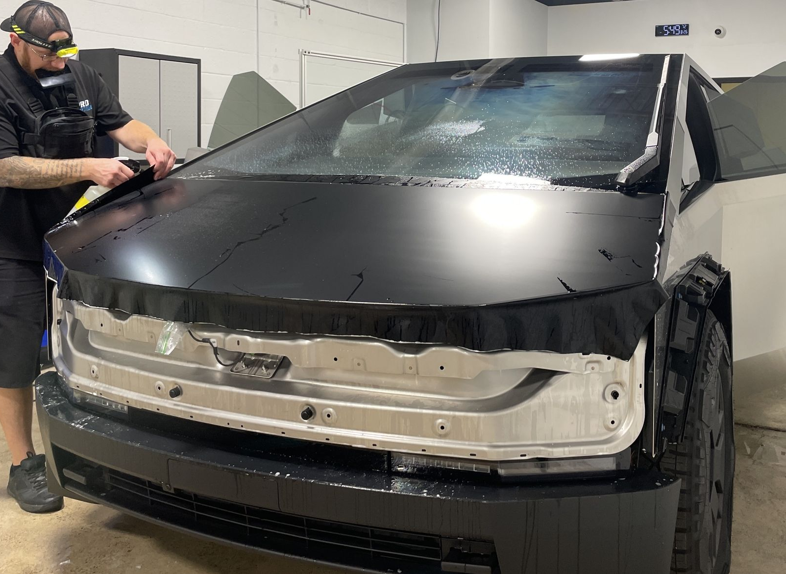 A man is applying window tinting to a car door
