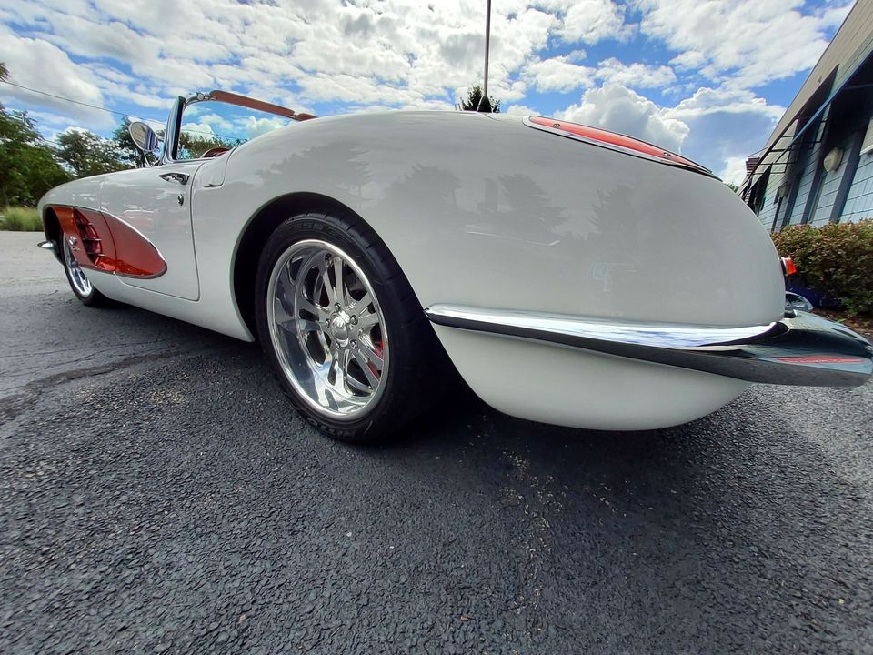 A white corvette convertible is parked on the side of the road.
