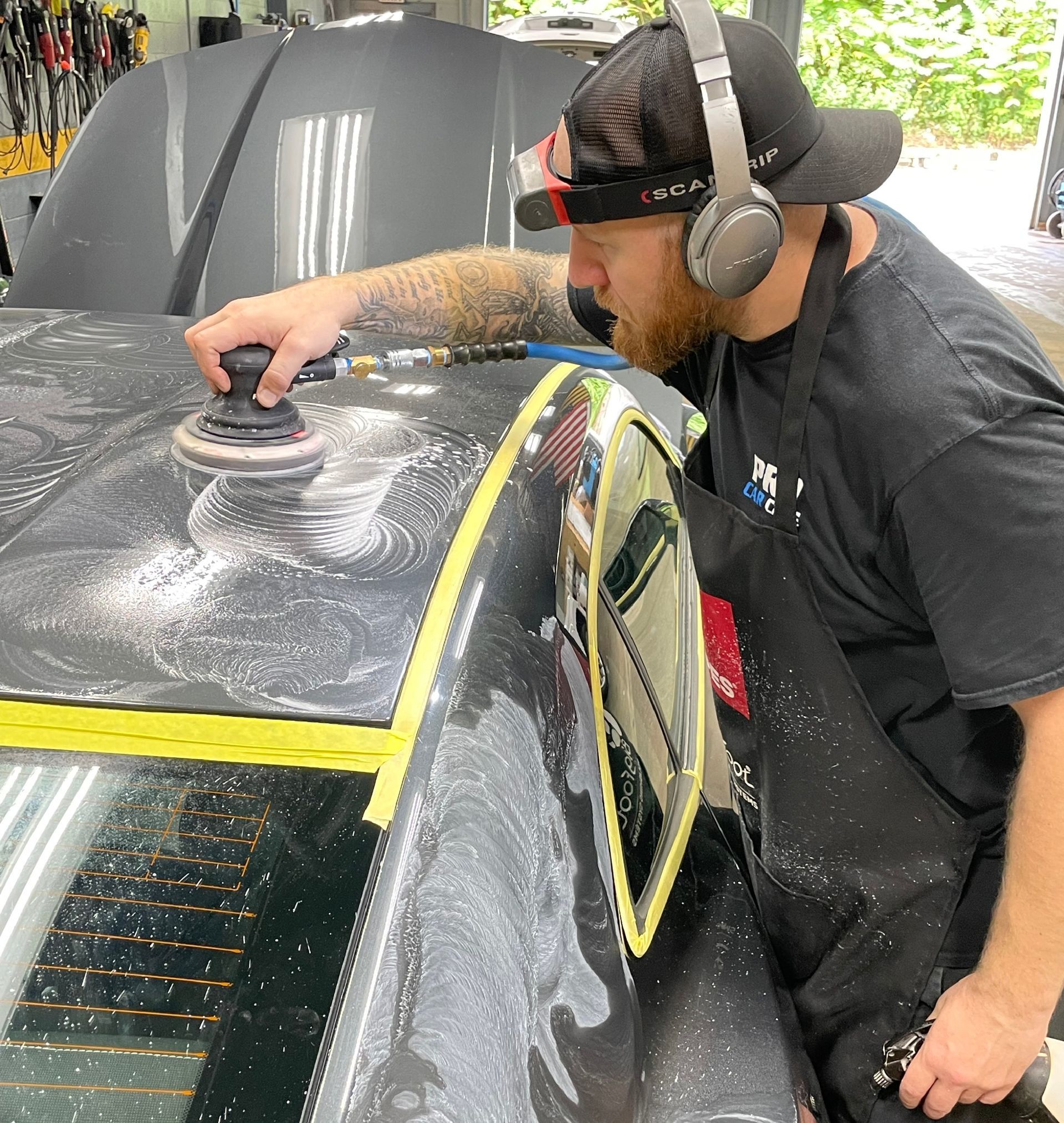 A person is washing a car wheel with foam